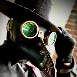 A photograph of the artist, Tea, dressed in a steampunk-inspired plague doctor mask.